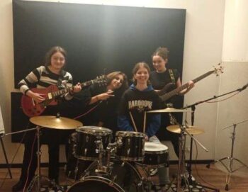 Quatre jeunes filles posent dans un studio avec des instruments de musique