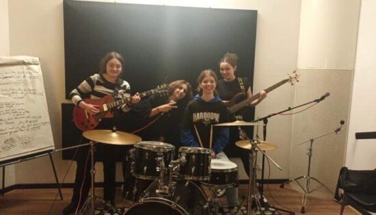 Quatre jeunes filles posent dans un studio avec des instruments de musique