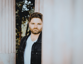 Portrait d'un homme au regard pénétrant entre deux colonnes de pierre