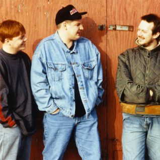Photo vintage de trois jeunes adultes les mains dans les poches