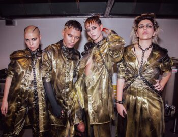 Portrait des quatre artistes posant en tenue dorée avec des chaines et un maquillage gothique