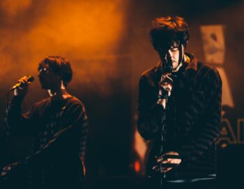 Deux chanteurs sur scène dans une lumière très tamisée