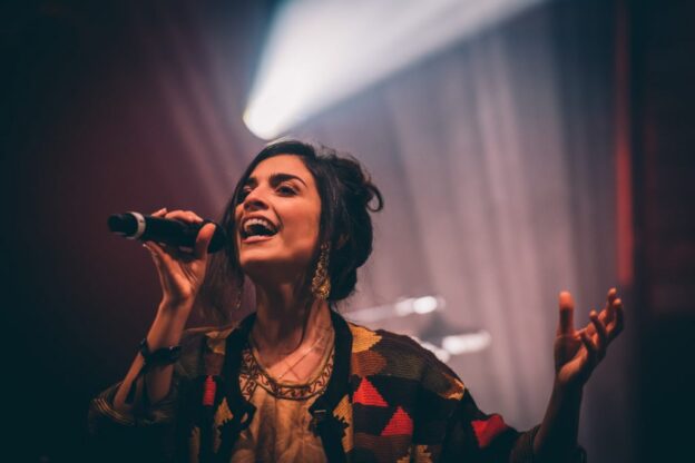 une femme chante avec un très grand sourire