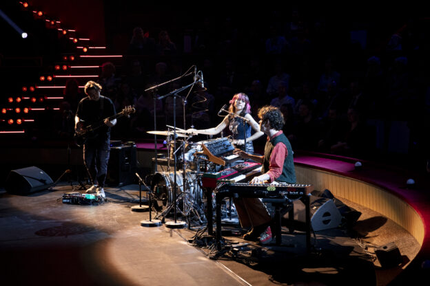 Trio de musiciens sur une scène de type théâtre