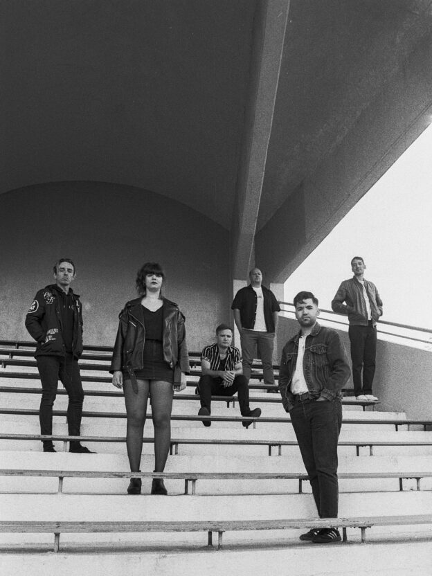 Plusieurs personnes posent à différents niveaux des gradins d'une structure en extérieur